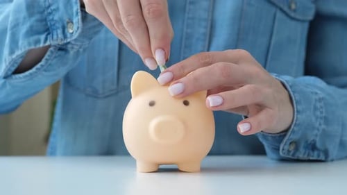 Woman Putting Paper Money Into Piggy Bank for Saving Money Accumulation