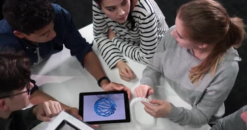 Étudiants avec tablette numérique regardant un prototype