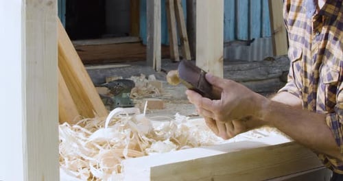 Man Smoothing Wood with Hand Plane Tool Outside