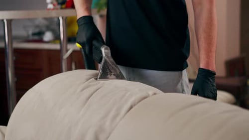 Man Cleaning Sofa With Upholstery Cleaner Machine