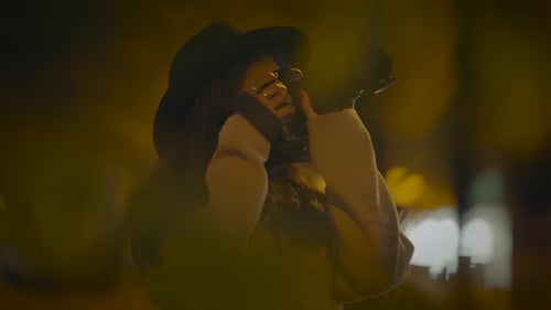 Woman Taking Photos at Night in City
