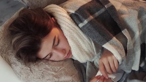 Woman Resting with Blanket and Tissue Indoors