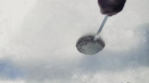 Slow Motion Of Man Scooping Out Water From Hole In Ground