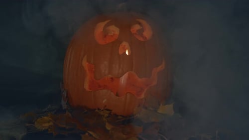 Glowing Halloween Pumpkin with Fog and Autumn Leaves