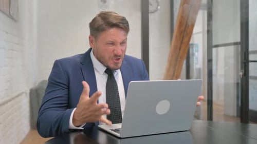 Man in Suit Working on Laptop at Desk