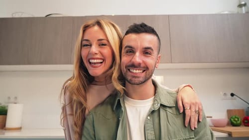 Caucasian Couple Holding and Showing the Key to Their New Apartment or House to the Camera Happy