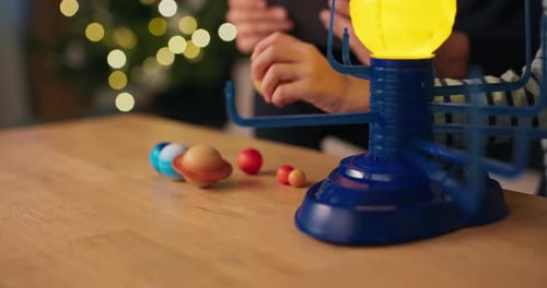 Closeup of the Hands of a Young Boy Assembling a Solar System