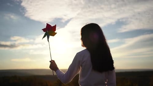 Little Baby Girl Silhouette Play with Windmill Toy Wind in the Park