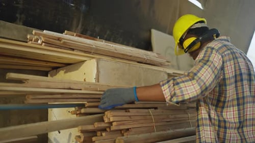 Side view of African American carpenter or woodworker or charpentier man use measuring tape to work
