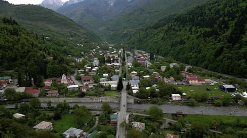 Drone flying over a little town on the valley of the green mountains of Georgia