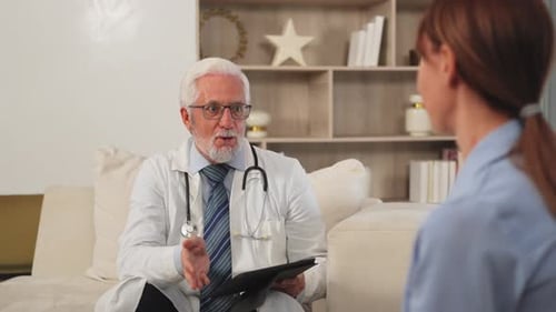 Senior Man Doctor Examining Young Woman in Doctor Office Clinic or at Home Girl Patient and Doctor