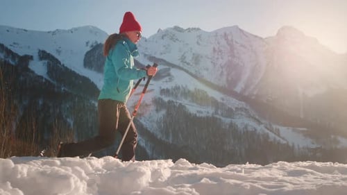Woman Hiking Snowy Mountain at Sunrise