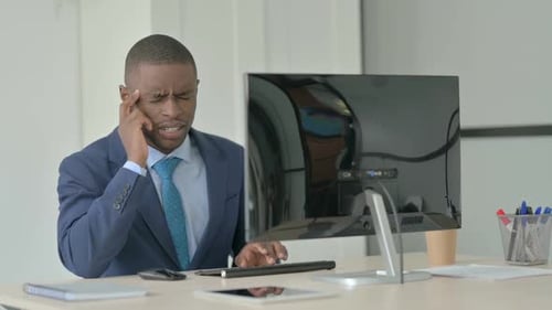 Man Experiencing Headache While Working at Computer
