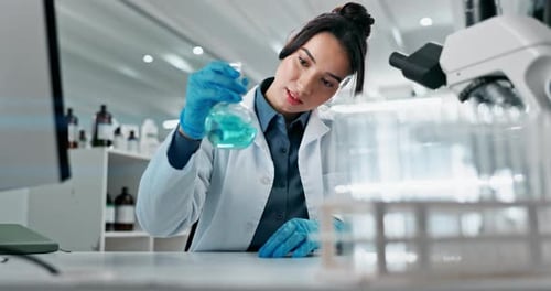 Woman Scientist Holding Blue Solution in Lab