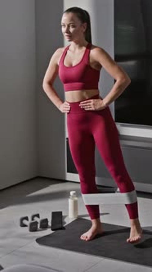 Woman Exercising Legs with Resistance Band at Home