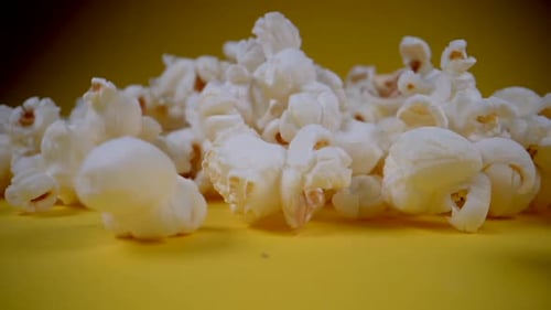 Close Up of Popcorn Falling on Yellow Surface