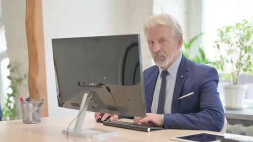 Senior Man Working at Computer in Office