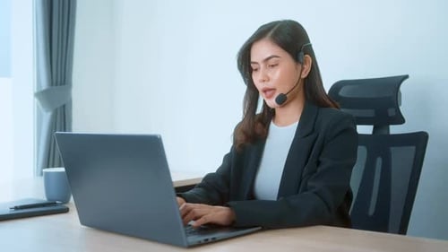 Female call center agent with headset consulting clients online