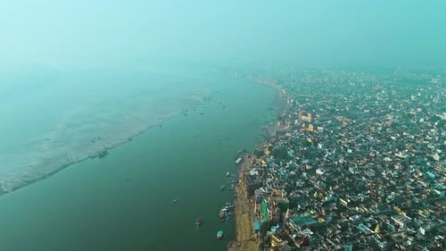 Kashi’s Tranquil Sunrise: Aerial Shot of Ganga River and Ghats with Boats