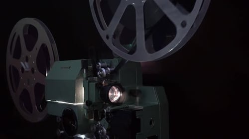 Vintage 8mm Film Projector Reels Spinning in Dark