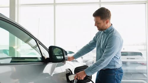 Man Charging Electric Car in Showroom