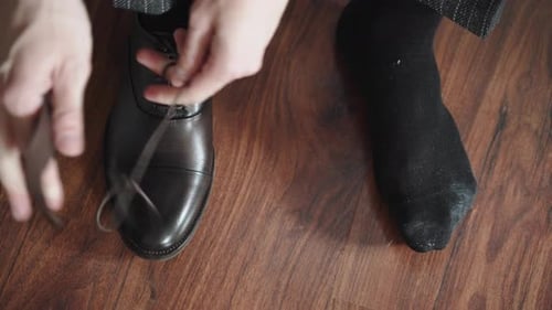Man Tying Shoelaces on Leather Dress Shoes