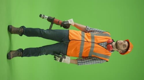 Vertikale Aufnahme: Bauingenieur, der den Perforator hochhebt und gerade schaut