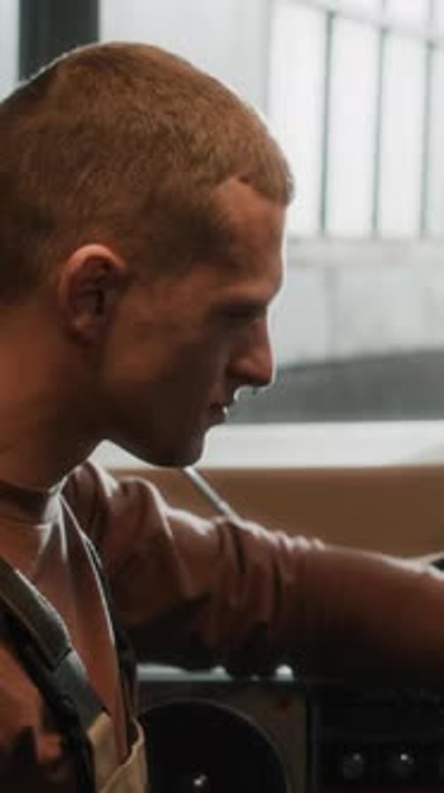 Portrait of Repairman Listening to Music in Workshop