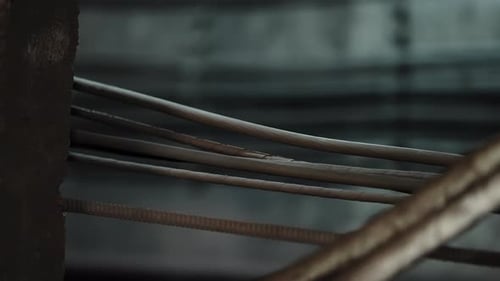 Closeup of Industrial Cables and Rebar Crossing in a Dim Construction Interior Showing Textured