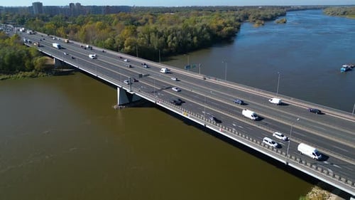 Aerial view of road bridge highway across the river in city area. Lorry is driving on the bridge. Sk