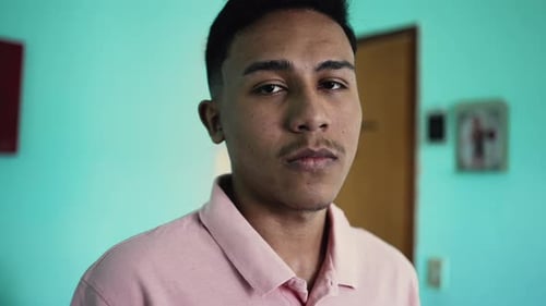 A serious hispanic young man portrait face looking at camera