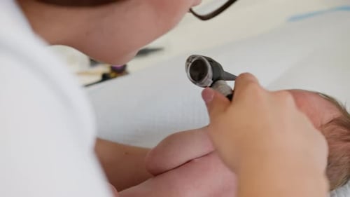 Newborn Infant Getting Examined by Doctor