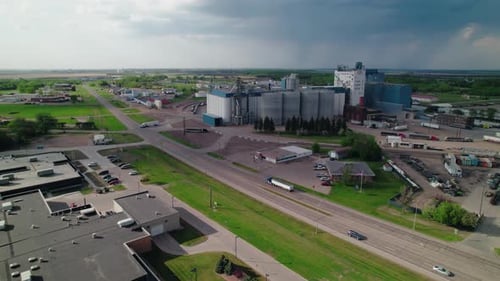 Aerial drone shot of a grain elevator and silos along a highway in Fargo, North Dakota, showcasing r