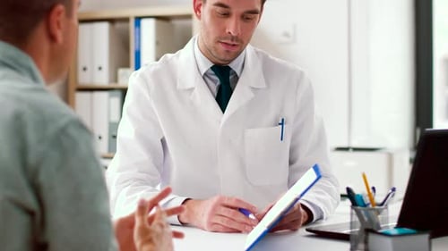 Doctor reviewing medical report with patient in office
