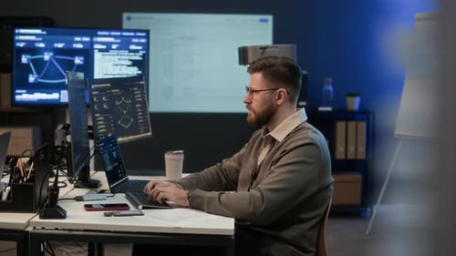 Konzentrierter Analyst, der an Computern im Network Center arbeitet