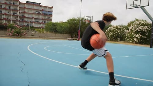 Teen Practices Basketball Jump Shot on Urban Court
