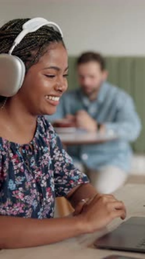 Woman, headphones and laptop for video call at cafe with communication, webinar and education class
