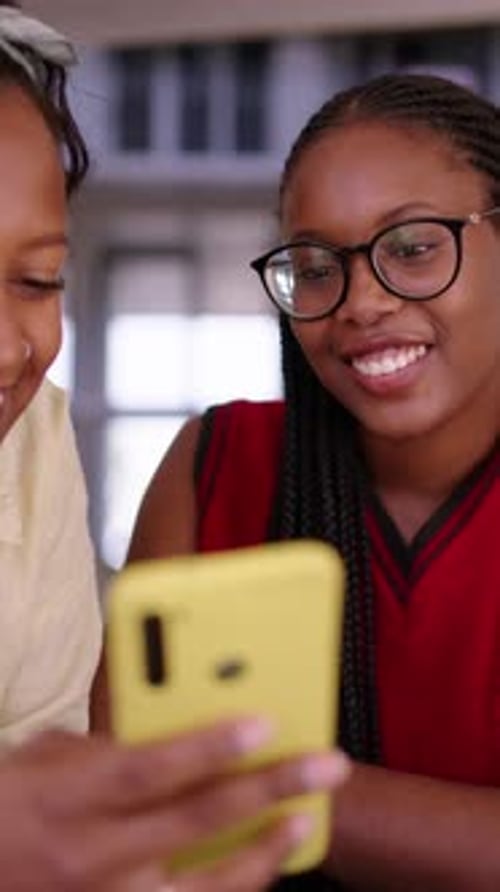 Happy Young Women Laughing at Smartphone