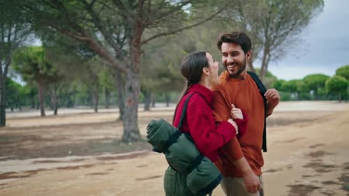 Happy Carefree Couple Hiking on Autumn Forest with Backpacks. Joyful Young Tourists