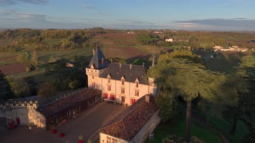 Beautiful sunrise over historical castle Pressac surrounded by trees and gardens