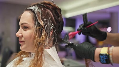 Businesswoman's Hair Coloring By Professional Female Hairdresser in Studio