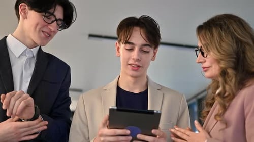 Business meeting in an office, female team leader and two young workers discussing business affairs