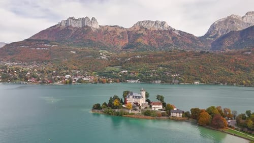 Chateau de Duingt aerial view over Lake Annecy and surrounding autumn mountains in France