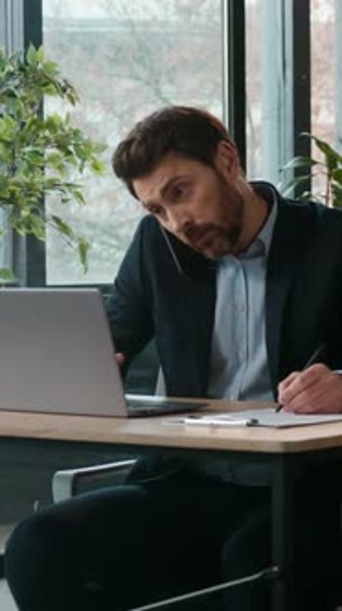 Busy Caucasian Business Man in Office Typing Laptop Talking Mobile Phone Quarrel Professional Male