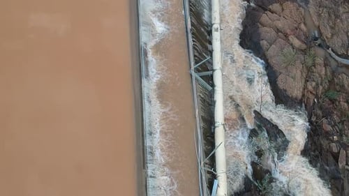 Flood waters cascading over a dam wall from a drone 3
