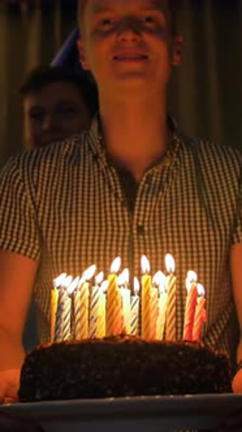 Adult Smiles Holding Birthday Cake With Candles