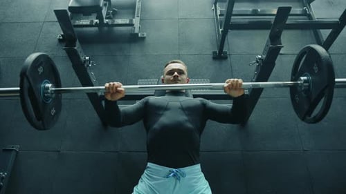 Medium Shot of Athletic Handsome Young Man Performing Bench Press in Gym