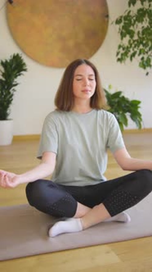 Vertical Portrait In a Serene Natural Environment a Tranquil Young Woman Practices Yoga Meditation