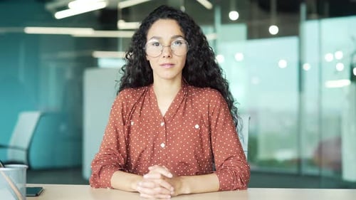 Webcam view. Young female employee watching video call training looking at camera while sitting