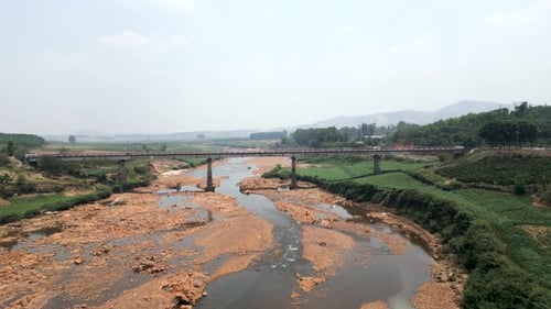 Large Bridge Seen From a Drone That Crosses a Large River with Little Flow Between the Mountains of